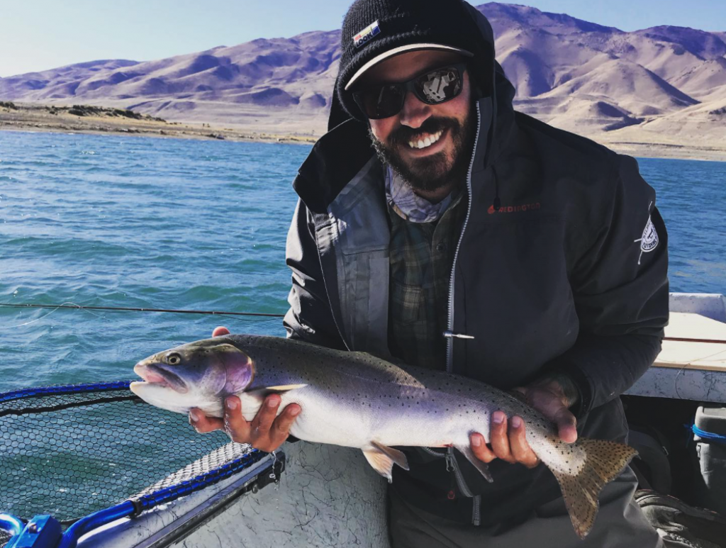 Bearded fly fisherman wearing a jacket and Smith Outback Sunglasses holding a large Trout | Best fly fishing sunglasses | Jumping Rise