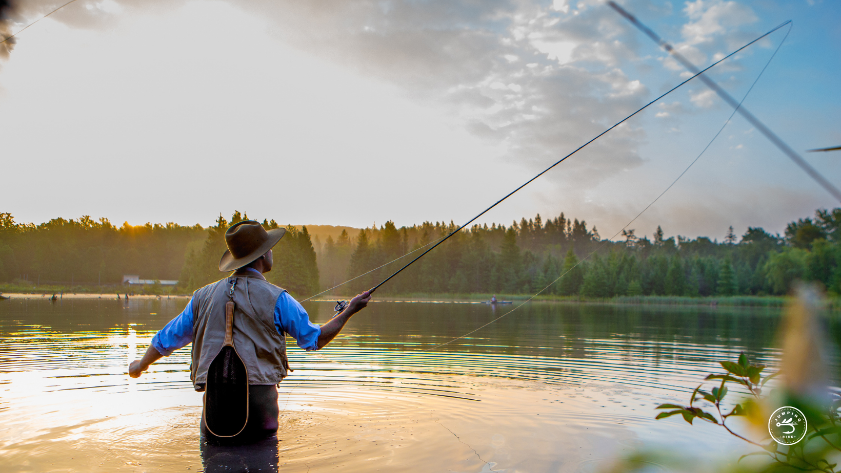 Fly fisherman in stream with hip waders | Jumping Rise